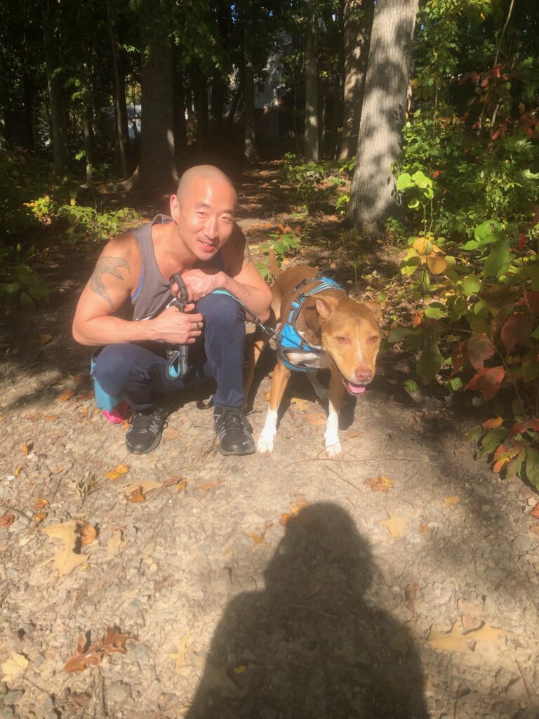 Personal trainer Aric Lee with his dog Private Benjamin in the woods – EvolveToFit Arlington VA